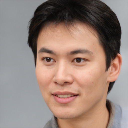 Joyful asian young-adult male with short  brown hair and brown eyes