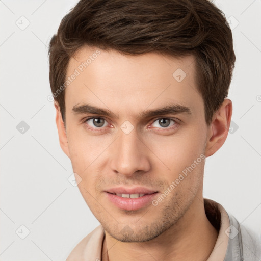 Joyful white young-adult male with short  brown hair and grey eyes