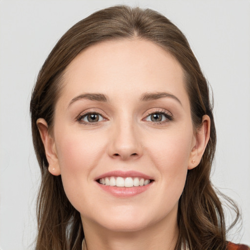 Joyful white young-adult female with long  brown hair and blue eyes