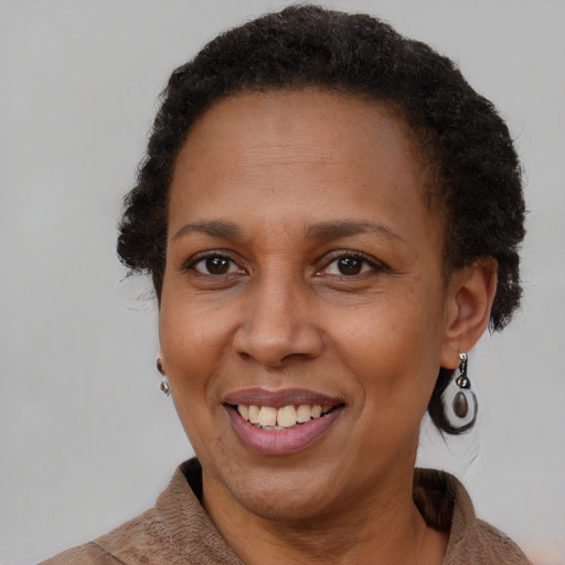 Joyful black adult female with short  brown hair and brown eyes