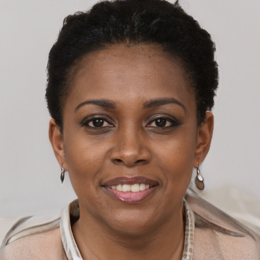 Joyful black young-adult female with short  brown hair and brown eyes