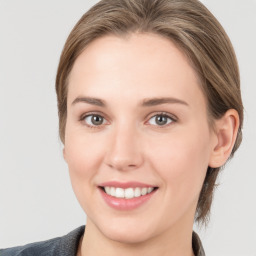 Joyful white young-adult female with medium  brown hair and grey eyes