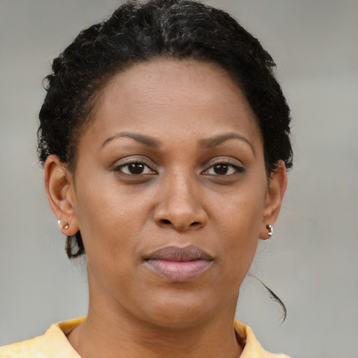 Joyful black young-adult female with short  brown hair and brown eyes