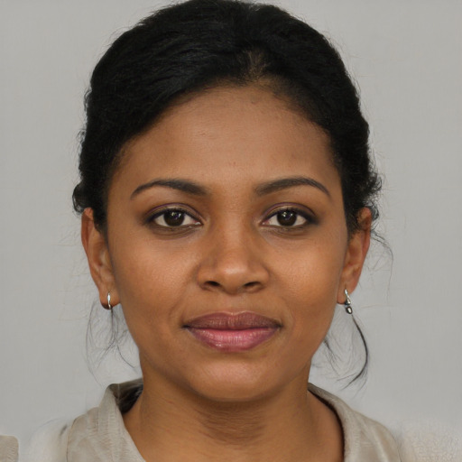 Joyful black young-adult female with short  brown hair and brown eyes