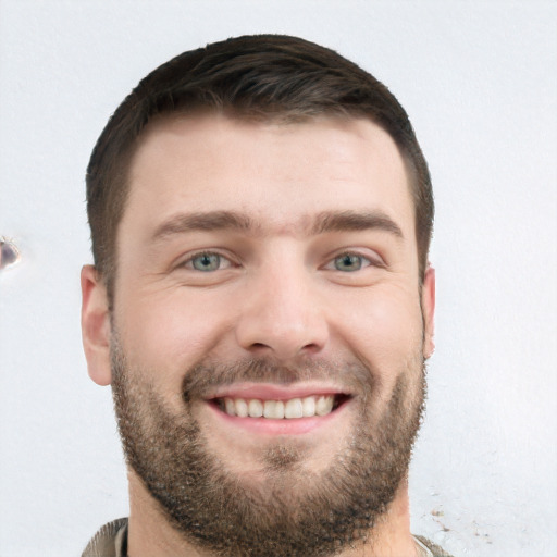 Joyful white young-adult male with short  brown hair and grey eyes