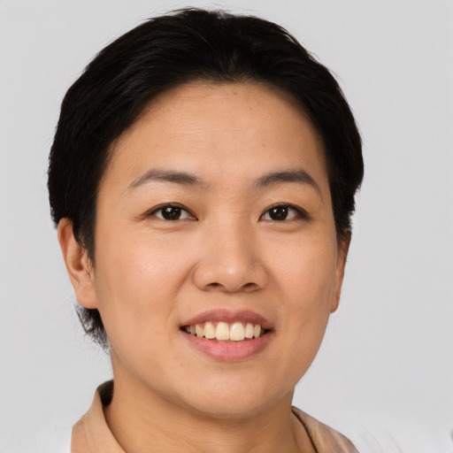 Joyful asian young-adult female with short  black hair and brown eyes
