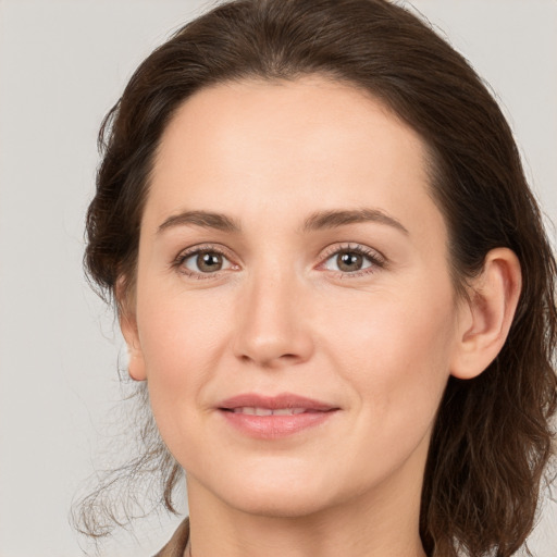 Joyful white young-adult female with medium  brown hair and grey eyes