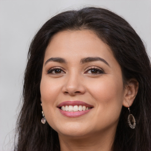 Joyful latino young-adult female with long  brown hair and brown eyes
