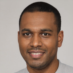 Joyful black young-adult male with short  black hair and brown eyes