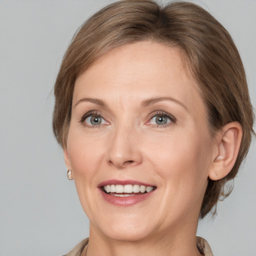 Joyful white adult female with medium  brown hair and grey eyes