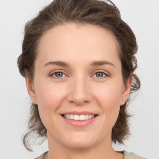 Joyful white young-adult female with medium  brown hair and grey eyes