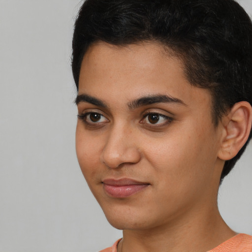 Joyful latino young-adult female with short  black hair and brown eyes