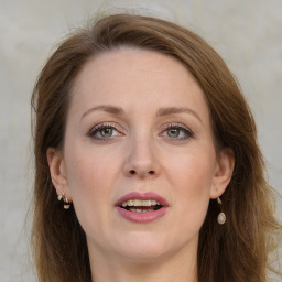 Joyful white adult female with long  brown hair and grey eyes