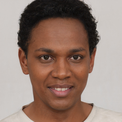 Joyful black young-adult male with short  brown hair and brown eyes