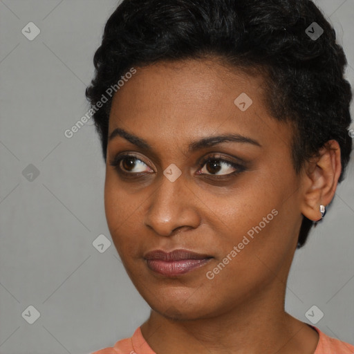 Joyful black young-adult female with short  black hair and brown eyes