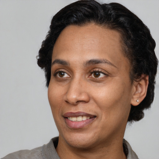 Joyful latino adult female with short  black hair and brown eyes
