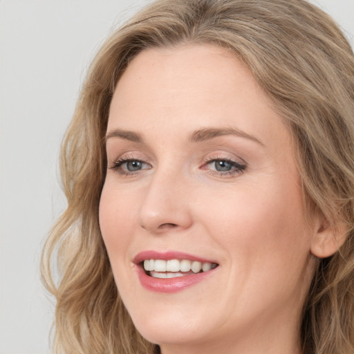 Joyful white young-adult female with long  brown hair and blue eyes