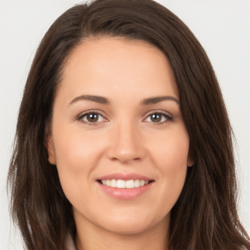 Joyful white young-adult female with long  brown hair and brown eyes