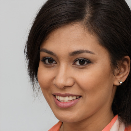 Joyful latino young-adult female with long  brown hair and brown eyes