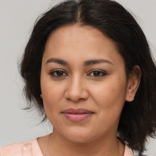 Joyful latino young-adult female with medium  brown hair and brown eyes