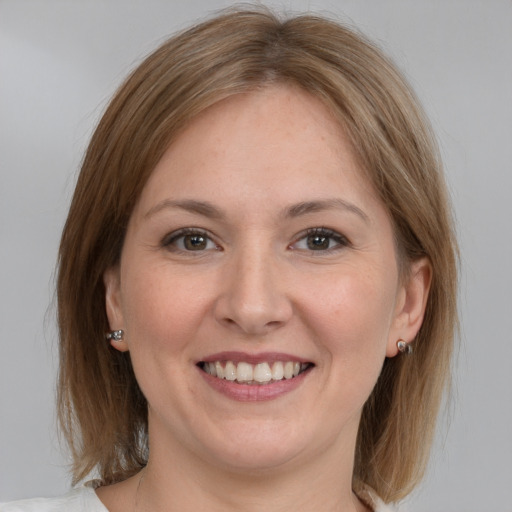 Joyful white young-adult female with medium  brown hair and grey eyes