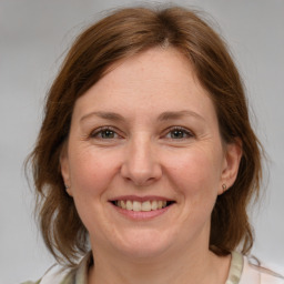 Joyful white adult female with medium  brown hair and grey eyes