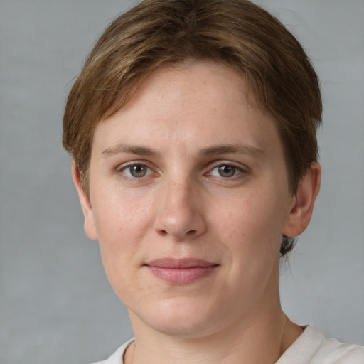 Joyful white young-adult female with short  brown hair and grey eyes