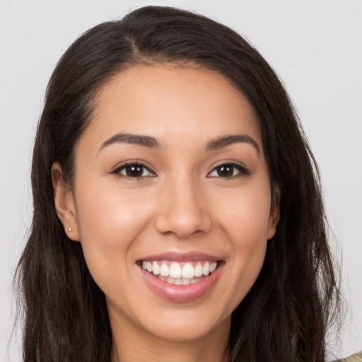 Joyful white young-adult female with long  brown hair and brown eyes