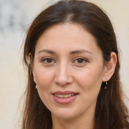 Joyful white adult female with long  brown hair and brown eyes