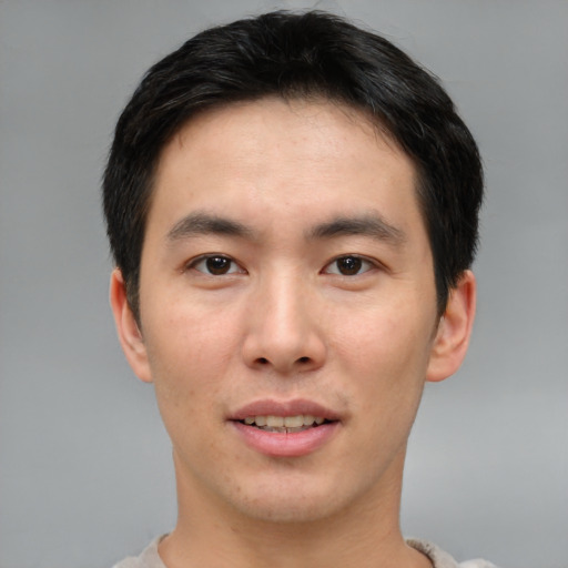 Joyful asian young-adult male with short  brown hair and brown eyes