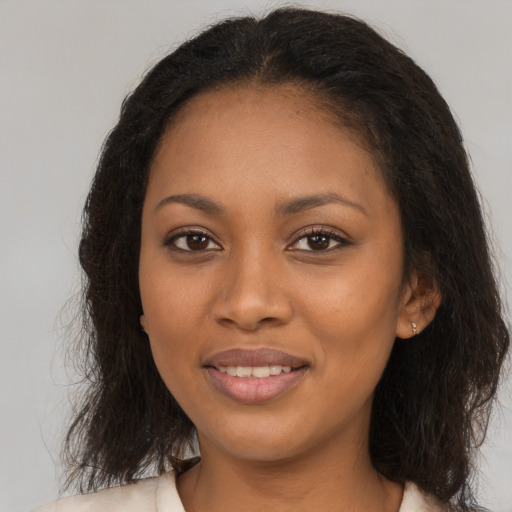 Joyful black young-adult female with long  brown hair and brown eyes