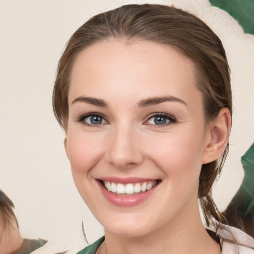 Joyful white young-adult female with medium  brown hair and green eyes