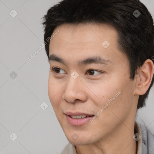 Joyful asian young-adult male with short  black hair and brown eyes