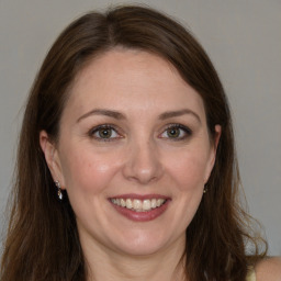 Joyful white adult female with long  brown hair and brown eyes