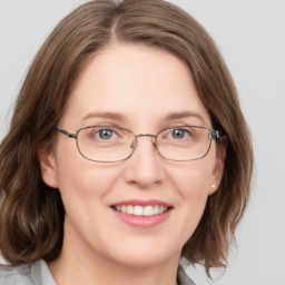 Joyful white adult female with medium  brown hair and grey eyes