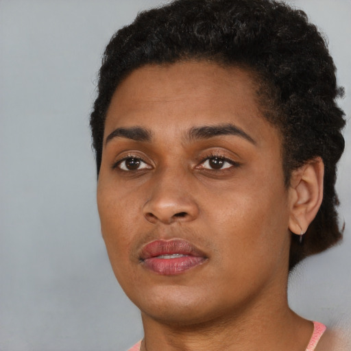 Joyful black young-adult female with short  black hair and brown eyes