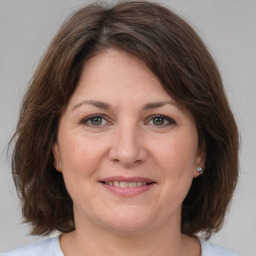 Joyful white adult female with medium  brown hair and grey eyes