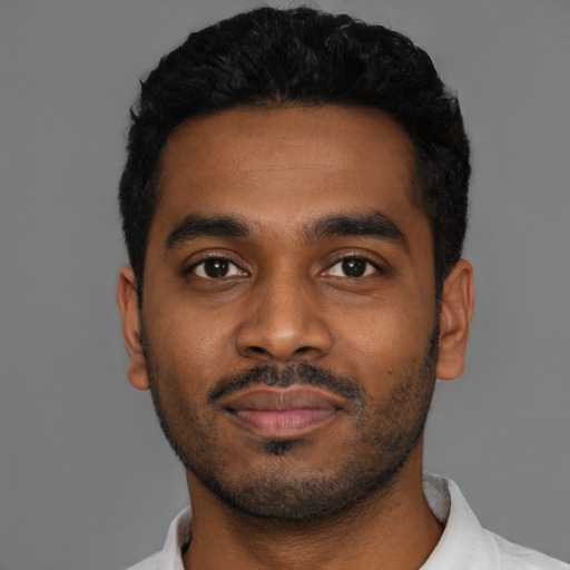 Joyful black young-adult male with short  black hair and brown eyes