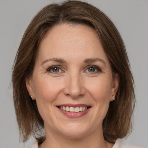 Joyful white adult female with medium  brown hair and grey eyes