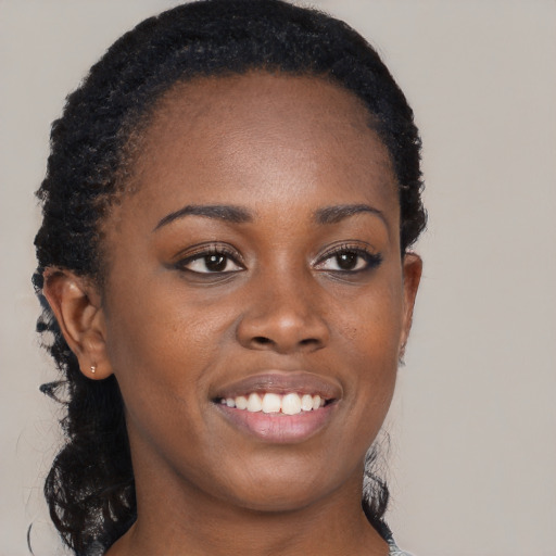 Joyful black young-adult female with long  brown hair and brown eyes