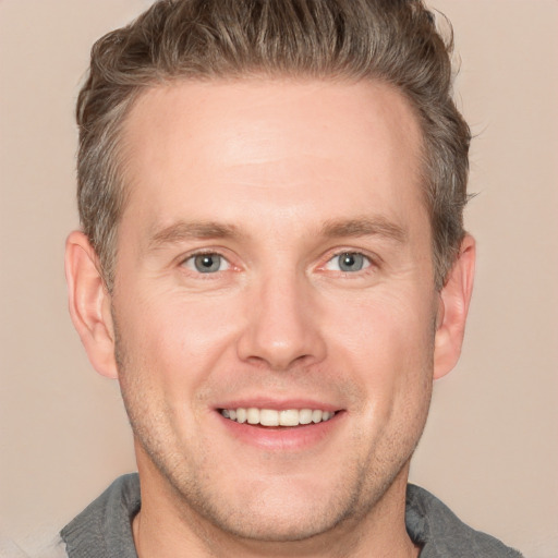 Joyful white adult male with short  brown hair and grey eyes