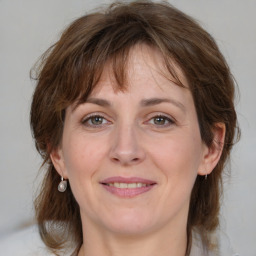 Joyful white adult female with medium  brown hair and grey eyes