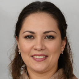 Joyful white adult female with long  brown hair and brown eyes