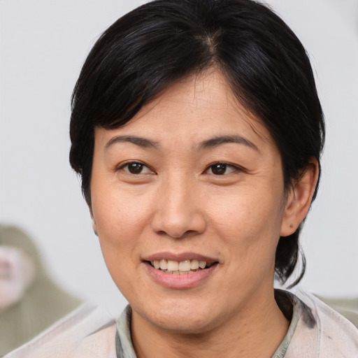 Joyful asian adult female with medium  brown hair and brown eyes