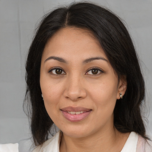 Joyful latino young-adult female with medium  brown hair and brown eyes