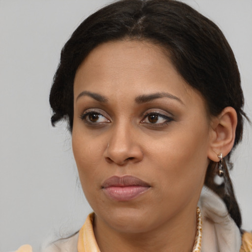 Joyful latino adult female with medium  brown hair and brown eyes
