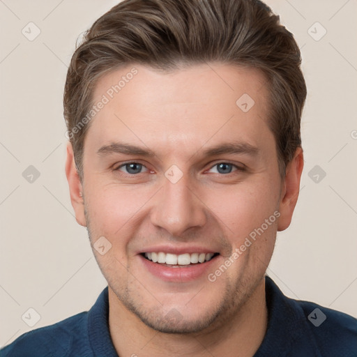 Joyful white young-adult male with short  brown hair and grey eyes