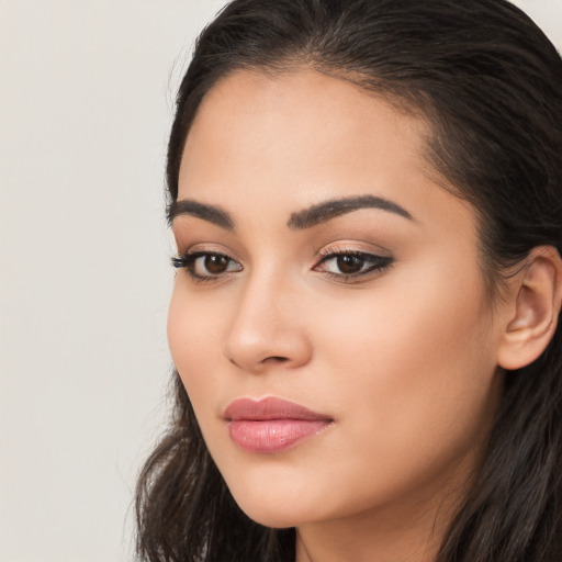 Joyful latino young-adult female with long  brown hair and brown eyes