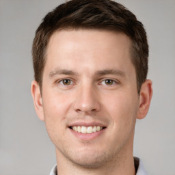 Joyful white young-adult male with short  brown hair and grey eyes