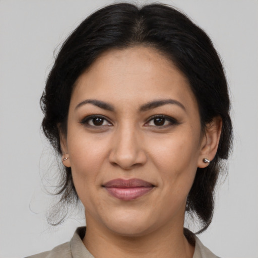 Joyful latino adult female with medium  brown hair and brown eyes